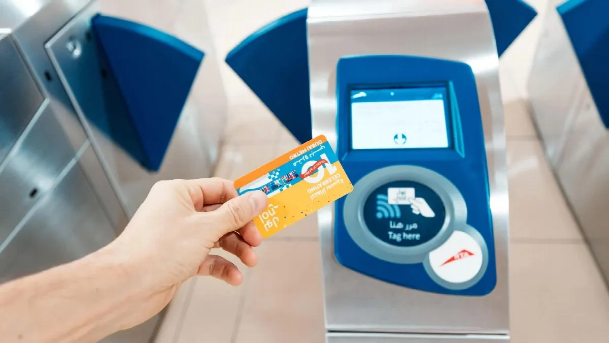 Person tapping Nol card at bus entrance with RTA logo visible