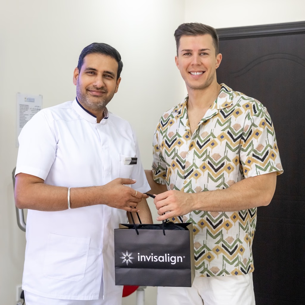 A dentist at Bella Medical Centre handing over an Invisalign aligner to a patient